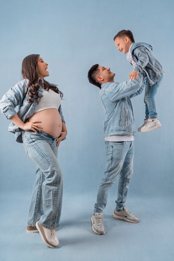 Familia esperando un bebé sobre fondo azul