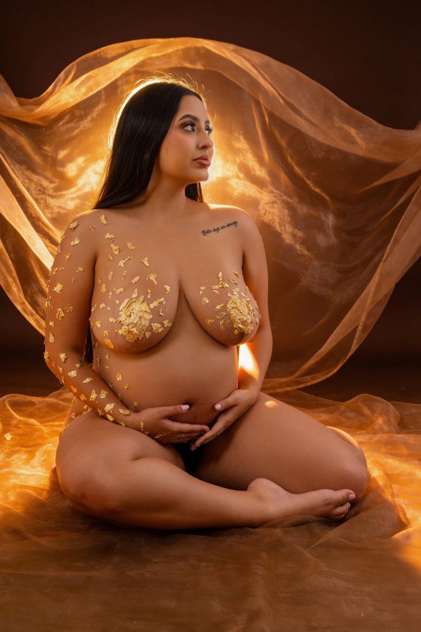 Retrato artístico de maternidad con detalles y velo dorados